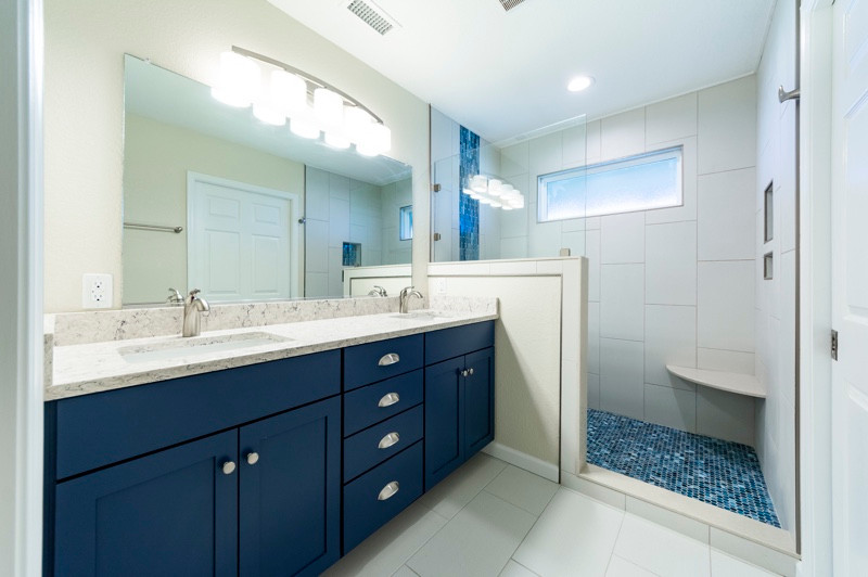Пример оригинального дизайна: главная ванная комната в морском стиле с синими фасадами, белой плиткой, открытым душем, бежевой столешницей, тумбой под две раковины, встроенной тумбой, белыми стенами, белым полом, фасадами в стиле шейкер, душем в нише, керамической плиткой, полом из цементной плитки, накладной раковиной, столешницей из гранита и стенами из вагонки