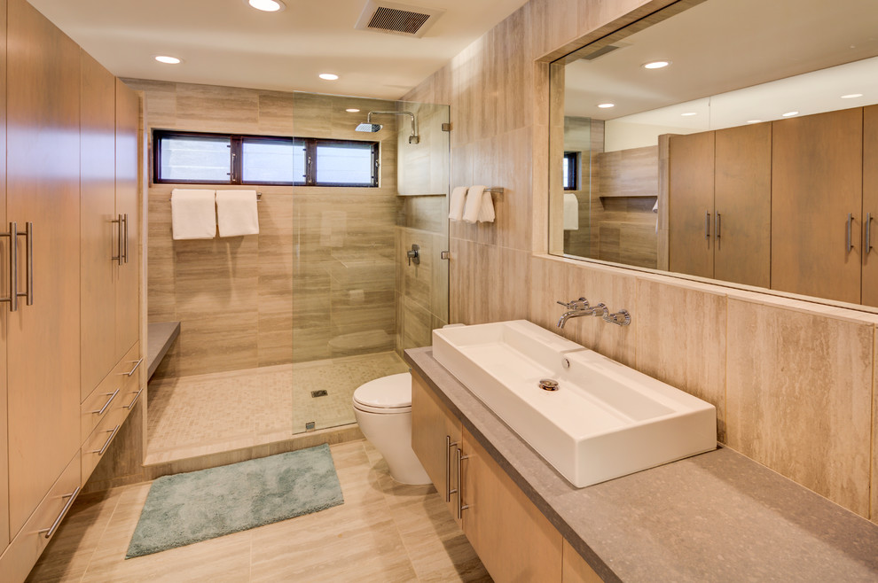 Diseño de cuarto de baño moderno grande con armarios con paneles lisos, puertas de armario de madera clara, ducha empotrada, sanitario de dos piezas, baldosas y/o azulejos beige, paredes beige y lavabo sobreencimera