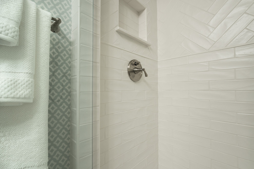 Inspiration för ett litet maritimt badrum, med luckor med infälld panel, vita skåp, en dusch i en alkov, vit kakel, porslinskakel, klinkergolv i porslin, ett undermonterad handfat och bänkskiva i akrylsten