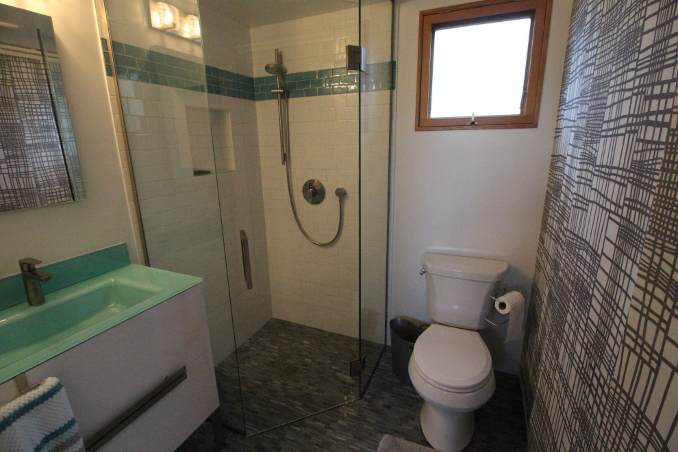 Aménagement d'une petite salle d'eau sud-ouest américain avec un placard en trompe-l'oeil, des portes de placard blanches, une douche d'angle, WC séparés, un carrelage blanc, des carreaux de porcelaine, un mur jaune, un sol en marbre, un plan vasque, un plan de toilette en verre, un sol gris, une cabine de douche à porte battante et un plan de toilette bleu.