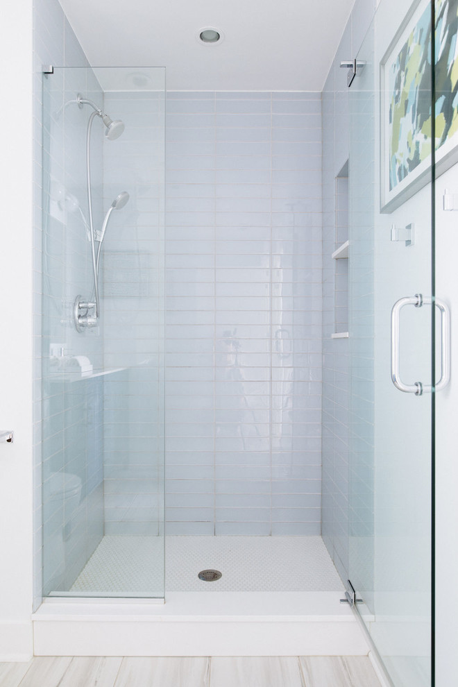 Bild på ett mellanstort funkis vit vitt badrum med dusch, med luckor med profilerade fronter, blå skåp, en dusch i en alkov, en toalettstol med hel cisternkåpa, grå kakel, vita väggar, klinkergolv i porslin, ett undermonterad handfat, bänkskiva i akrylsten, beiget golv och dusch med gångjärnsdörr