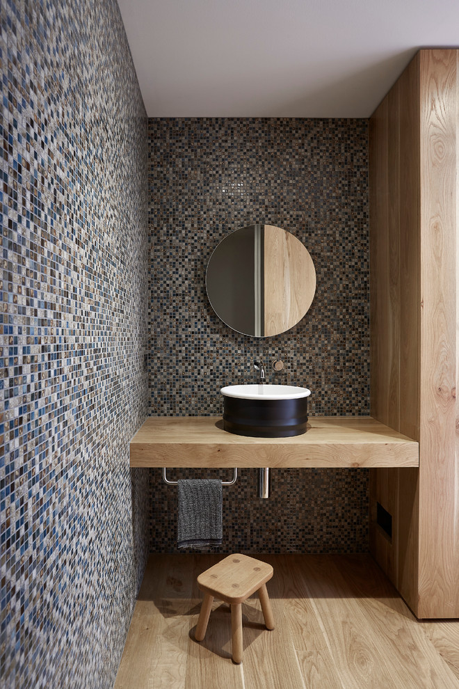 Foto de cuarto de baño actual extra grande con paredes multicolor, suelo de madera clara y lavabo sobreencimera