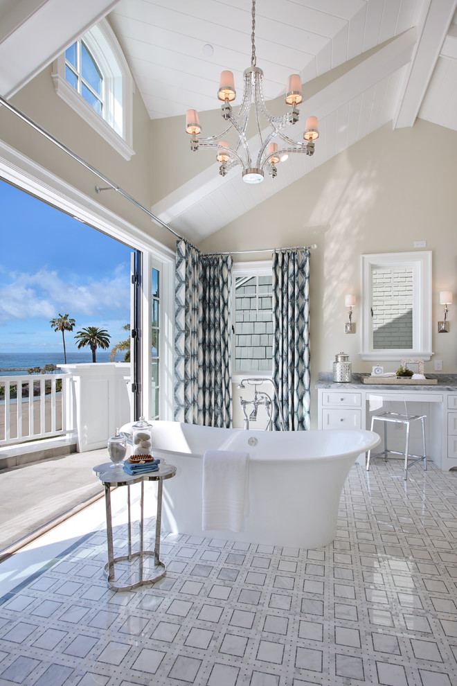 オレンジカウンティにあるビーチスタイルのおしゃれなマスターバスルーム (落し込みパネル扉のキャビネット、白いキャビネット、置き型浴槽、ベージュの壁) の写真