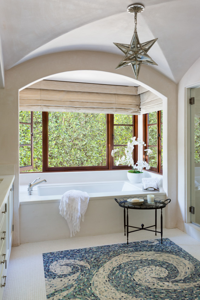 Photo of a medium sized mediterranean ensuite bathroom in Los Angeles with beaded cabinets, white cabinets, a submerged bath, a one-piece toilet, beige walls, marble flooring, a submerged sink, marble worktops, blue floors, white worktops, a shower bench, a single sink, a built in vanity unit and a vaulted ceiling.