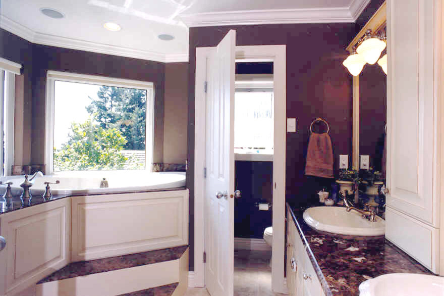 Example of a mid-sized classic brown tile and ceramic tile mosaic tile floor bathroom design in Vancouver with a drop-in sink, raised-panel cabinets, distressed cabinets, marble countertops, a two-piece toilet and brown walls