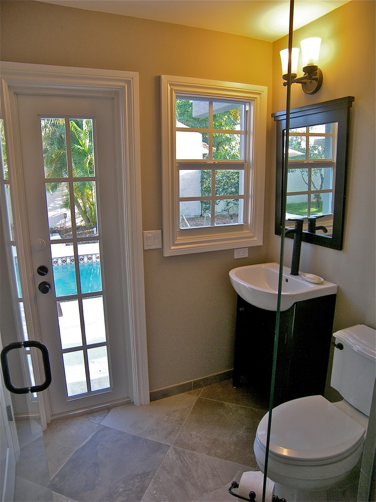 Klassisk inredning av ett mellanstort badrum med dusch, med ett undermonterat badkar, en dusch i en alkov, en toalettstol med separat cisternkåpa, stenkakel, klinkergolv i porslin, ett fristående handfat, granitbänkskiva och beige väggar