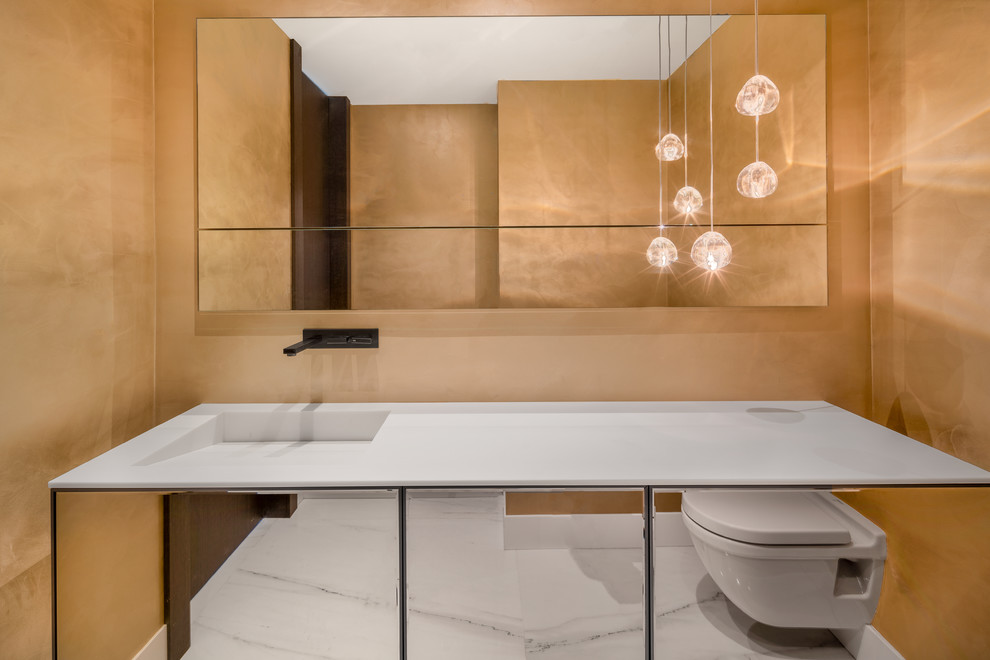 Inspiration för moderna vitt badrum, med luckor med glaspanel, vita skåp, en vägghängd toalettstol, gula väggar, marmorgolv, ett integrerad handfat och vitt golv