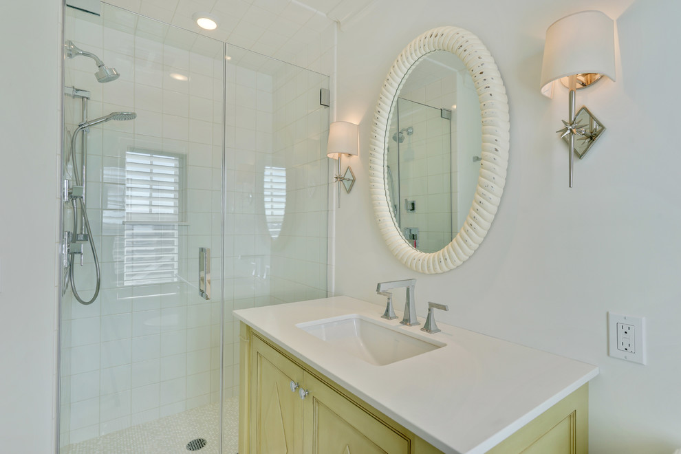 Cette photo montre une petite salle de bain bord de mer avec un placard à porte affleurante, des portes de placards vertess, un mur blanc, un lavabo encastré et un plan de toilette blanc.