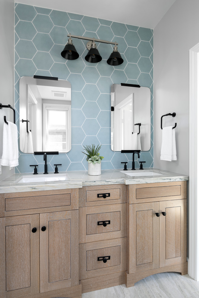 Ejemplo de cuarto de baño marinero con puertas de armario de madera clara, baldosas y/o azulejos azules, paredes grises, lavabo bajoencimera, suelo gris, encimeras grises, aseo y ducha y armarios estilo shaker