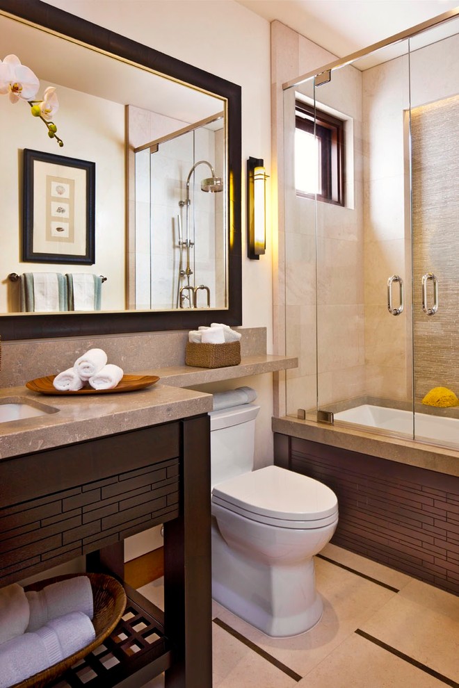 Пример оригинального дизайна: ванная комната среднего размера в современном стиле с врезной раковиной, открытыми фасадами, темными деревянными фасадами, ванной в нише, душем над ванной, бежевой плиткой, столешницей из известняка, унитазом-моноблоком, бежевыми стенами, полом из известняка, плиткой из известняка и окном