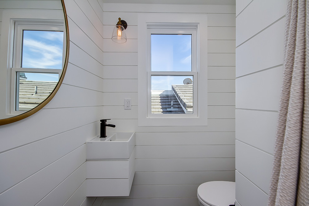 Idéer för maritima en-suite badrum, med skåp i shakerstil, blå skåp, ett fristående badkar, en dusch i en alkov, en toalettstol med hel cisternkåpa, vita väggar, mosaikgolv, ett väggmonterat handfat och marmorbänkskiva