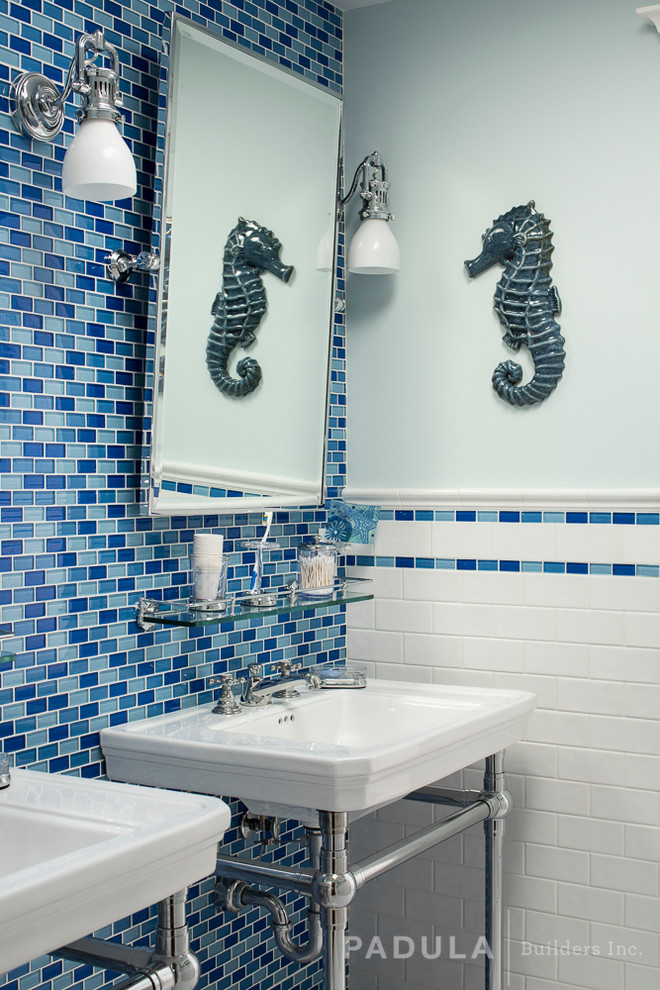 Photo of a beach style bathroom in New York with a console sink, blue tiles, metro tiles and blue walls.