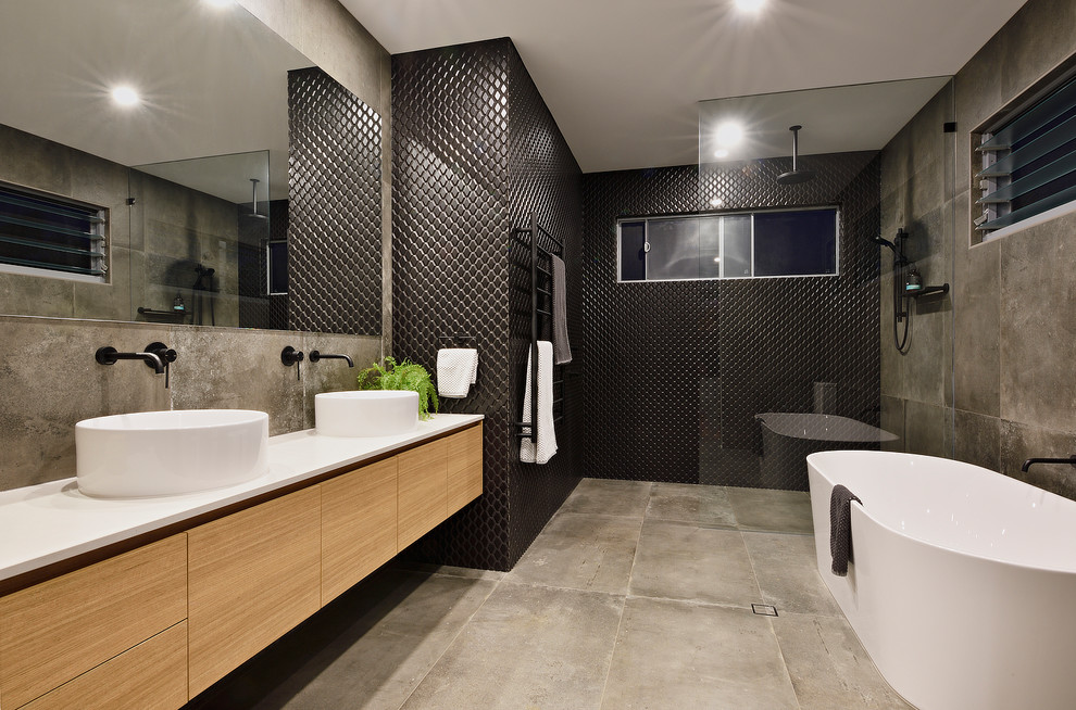 Идея дизайна: ванная комната среднего размера в современном стиле с коричневыми фасадами, полом из цементной плитки, настольной раковиной, серым полом, открытым душем, отдельно стоящей ванной, открытым душем, черной плиткой и душевой кабиной