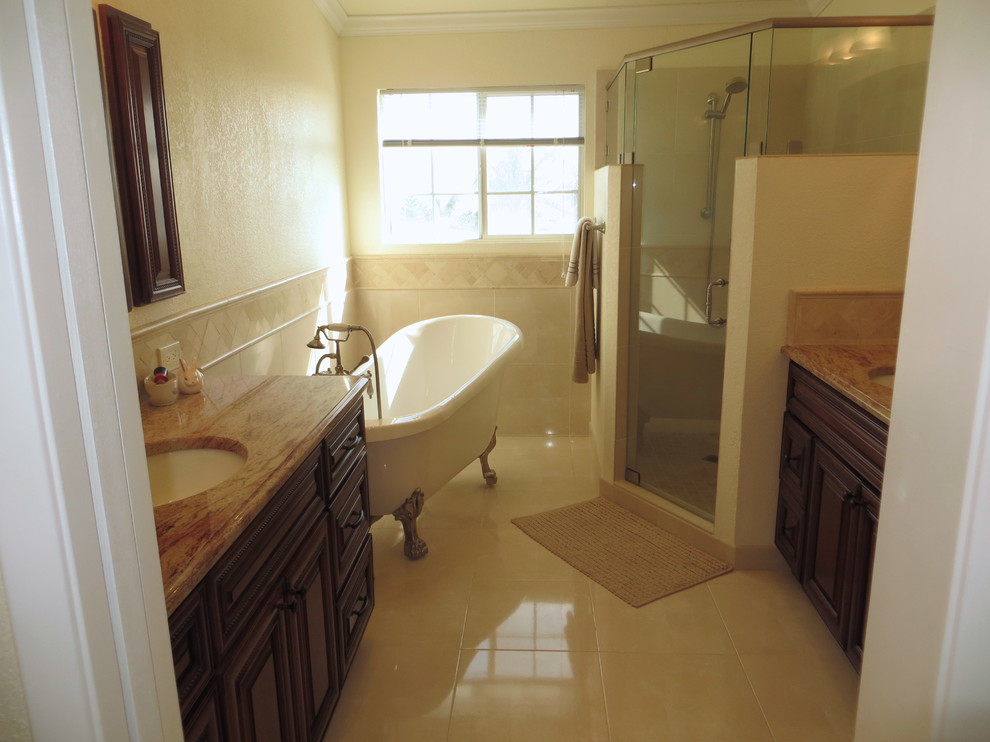 This is an example of a medium sized traditional bathroom in San Diego with a submerged sink, raised-panel cabinets, dark wood cabinets, granite worktops, a claw-foot bath, an alcove shower, a one-piece toilet, beige tiles, porcelain tiles, beige walls and porcelain flooring.