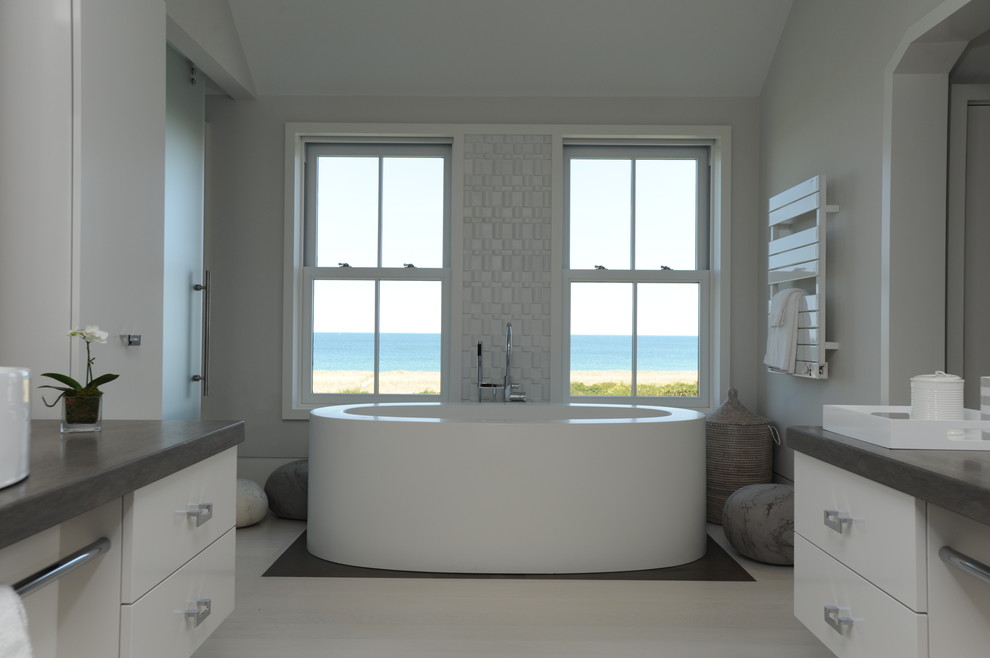Свежая идея для дизайна: главная ванная комната в морском стиле с плоскими фасадами, белыми фасадами, отдельно стоящей ванной и серыми стенами - отличное фото интерьера
