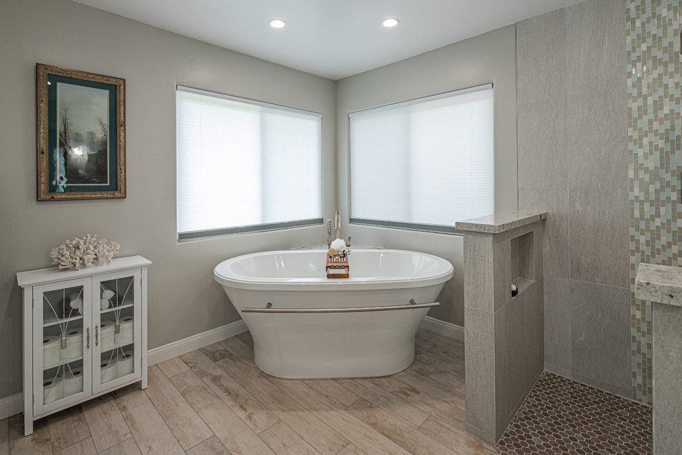 Идея дизайна: главная ванная комната среднего размера в стиле неоклассика (современная классика) с фасадами с утопленной филенкой, белыми фасадами, отдельно стоящей ванной, угловым душем, раздельным унитазом, серыми стенами, врезной раковиной, коричневым полом, открытым душем, разноцветной столешницей, серой плиткой, керамогранитной плиткой, светлым паркетным полом и столешницей из гранита