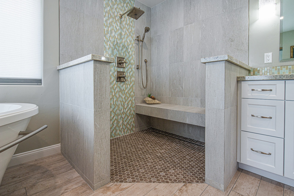 Свежая идея для дизайна: главная ванная комната среднего размера в стиле неоклассика (современная классика) с фасадами с утопленной филенкой, белыми фасадами, отдельно стоящей ванной, угловым душем, раздельным унитазом, серыми стенами, врезной раковиной, коричневым полом, открытым душем, разноцветной столешницей, серой плиткой, керамогранитной плиткой, светлым паркетным полом и столешницей из гранита - отличное фото интерьера