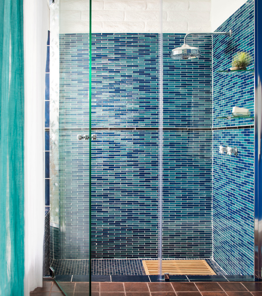 Пример оригинального дизайна: ванная комната в морском стиле с душем в нише, синей плиткой и стеклянной плиткой