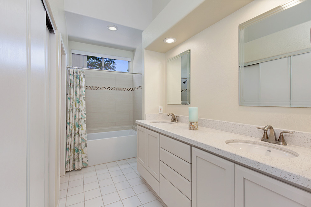 Design ideas for a medium sized traditional ensuite bathroom in San Diego with recessed-panel cabinets, white cabinets, an alcove bath, a two-piece toilet, beige tiles, porcelain tiles, beige walls, ceramic flooring, white floors, a shower curtain, a shower/bath combination, a submerged sink, engineered stone worktops, white worktops, double sinks and a built in vanity unit.