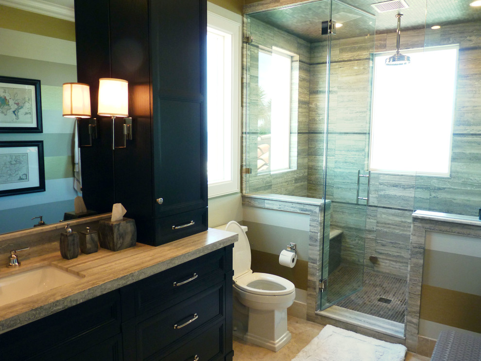 На фото: большая ванная комната в морском стиле с монолитной раковиной, фасадами с утопленной филенкой, темными деревянными фасадами, мраморной столешницей, отдельно стоящей ванной, душем в нише и бежевой плиткой