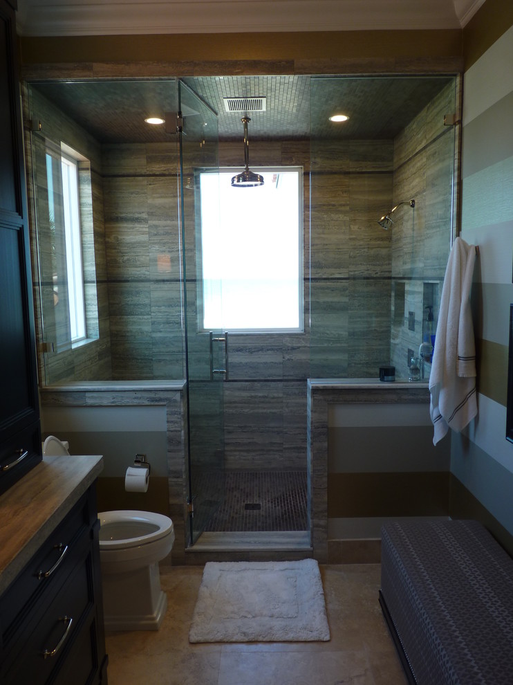 Modelo de cuarto de baño costero grande con lavabo integrado, armarios con paneles empotrados, puertas de armario de madera en tonos medios, paredes blancas, encimera de mármol, ducha empotrada y sanitario de una pieza