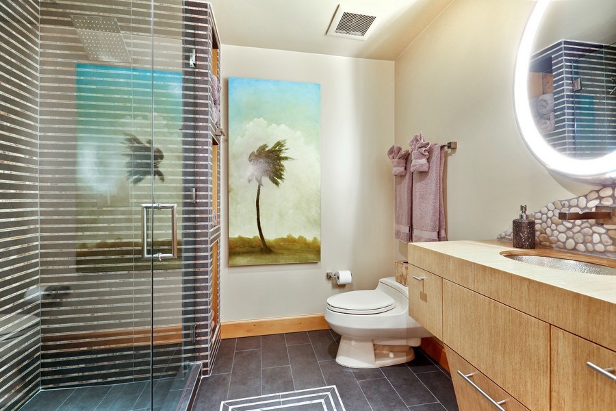 Medium sized world-inspired ensuite bathroom in Miami with flat-panel cabinets, medium wood cabinets, a corner shower, a one-piece toilet, black and white tiles, mosaic tiles, beige walls, ceramic flooring, a submerged sink, wooden worktops, grey floors, a hinged door and brown worktops.