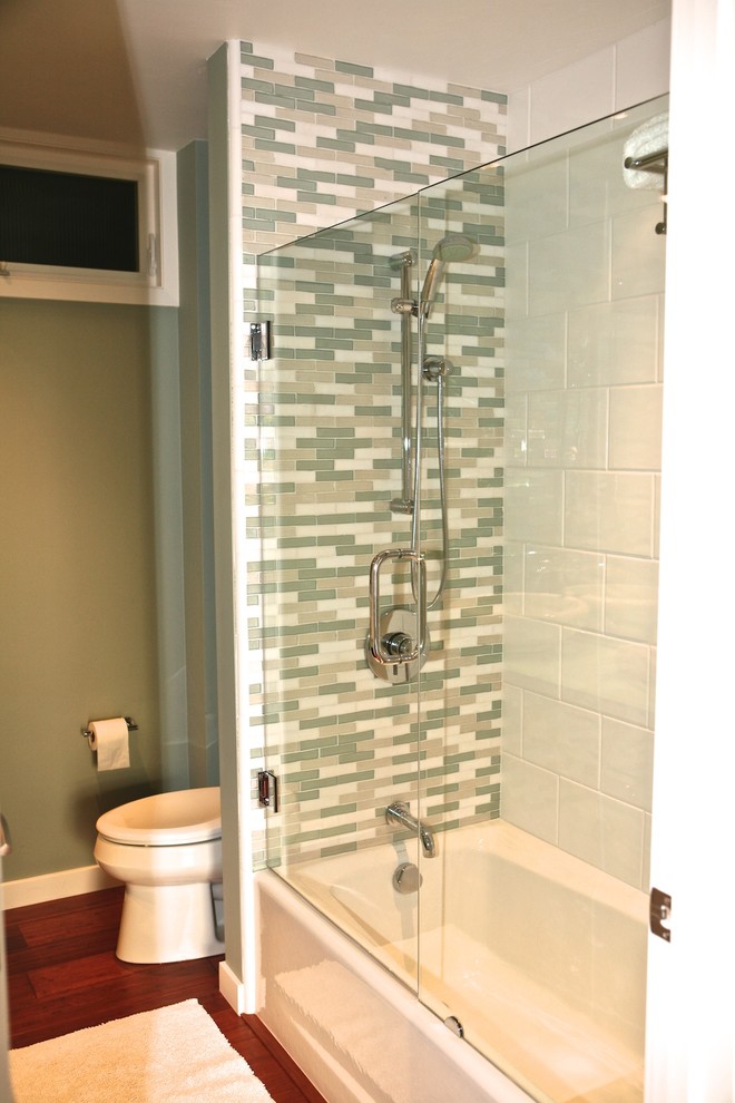 На фото: маленькая ванная комната в современном стиле с настольной раковиной, ванной в нише, душем над ванной, унитазом-моноблоком, синей плиткой, стеклянной плиткой, зелеными стенами и полом из бамбука для на участке и в саду