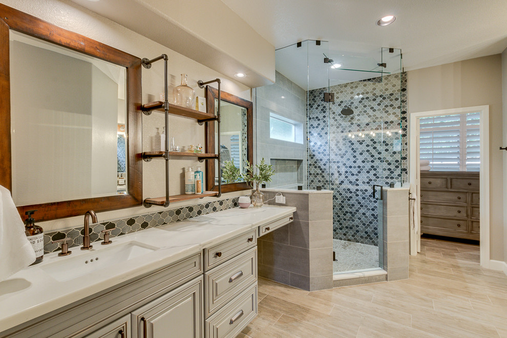 Example of a large urban master gray tile and ceramic tile ceramic tile and gray floor corner shower design in Phoenix with raised-panel cabinets, gray cabinets, a two-piece toilet, gray walls, an undermount sink, quartz countertops and a hinged shower door