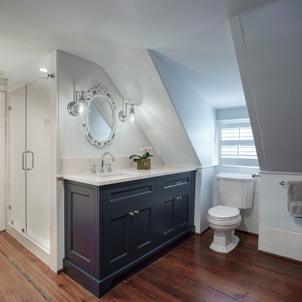 Idéer för ett mellanstort klassiskt vit badrum med dusch, med luckor med infälld panel, en dusch i en alkov, en toalettstol med separat cisternkåpa, vit kakel, porslinskakel, bänkskiva i kvarts, brunt golv, dusch med gångjärnsdörr, svarta skåp, grå väggar, mörkt trägolv och ett undermonterad handfat