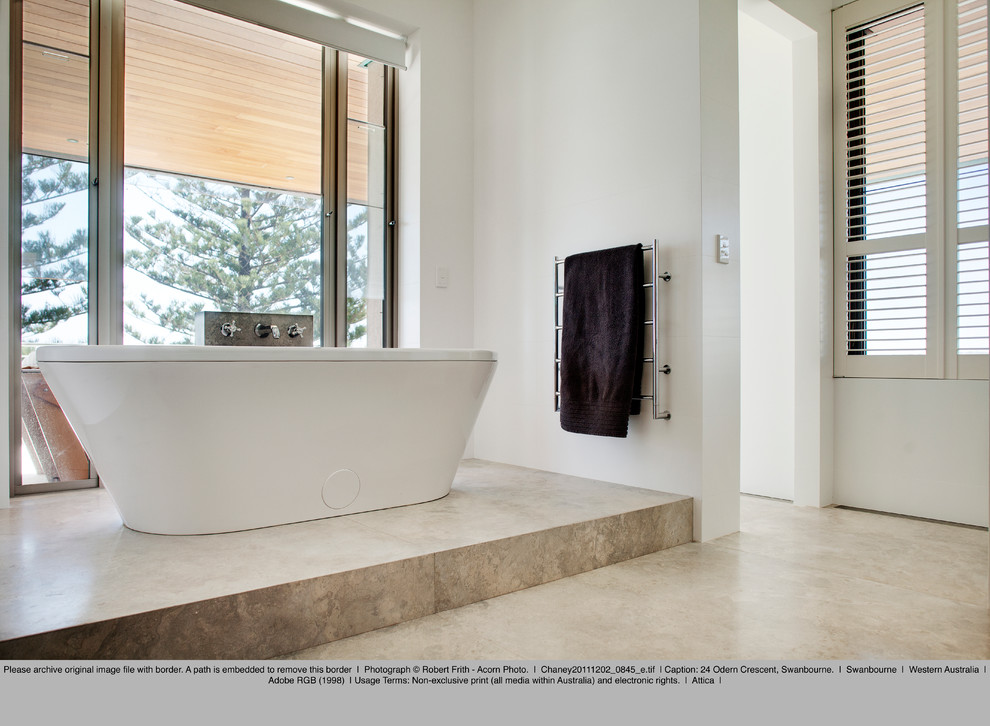 Immagine di una stanza da bagno padronale stile marino di medie dimensioni con vasca freestanding, piastrelle beige, piastrelle in pietra, pareti bianche e pavimento in travertino