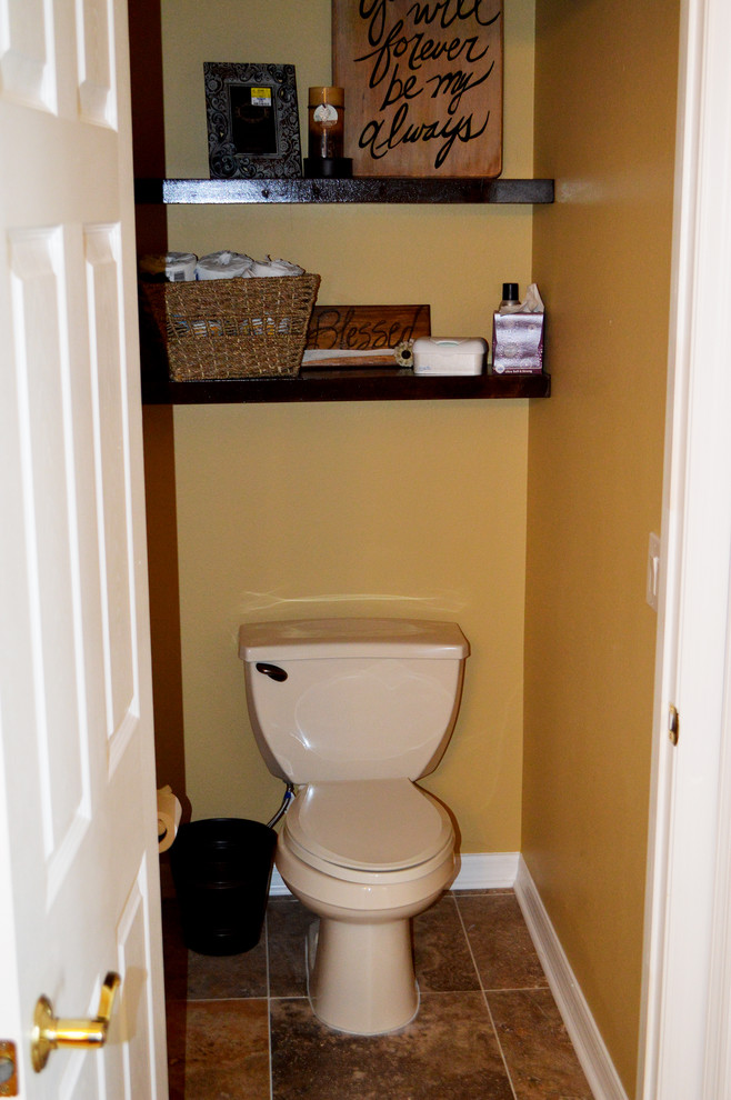 Стильный дизайн: большой туалет в классическом стиле с раздельным унитазом, коричневой плиткой, каменной плиткой, желтыми стенами и полом из травертина - последний тренд