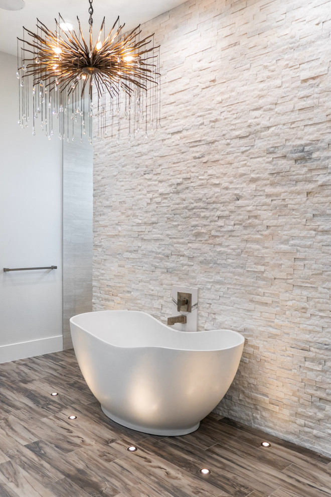 Huge trendy master beige tile, white tile and stone tile medium tone wood floor and brown floor japanese bathtub photo in Tampa with flat-panel cabinets, black cabinets, white walls, a vessel sink, quartzite countertops and white countertops