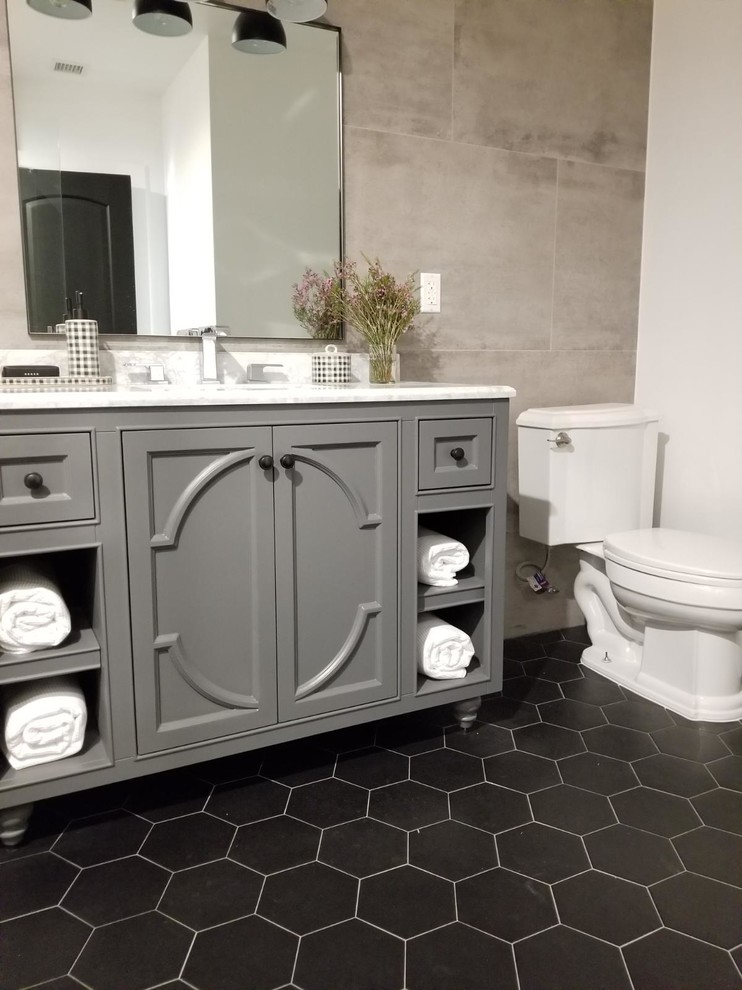 Aménagement d'une petite salle de bain principale campagne avec un placard en trompe-l'oeil, des portes de placard grises, une baignoire en alcôve, une douche d'angle, WC séparés, un carrelage gris, des carreaux de porcelaine, un mur gris, un sol en carrelage de céramique, un lavabo encastré, un plan de toilette en marbre, un sol noir, une cabine de douche à porte battante et un plan de toilette blanc.