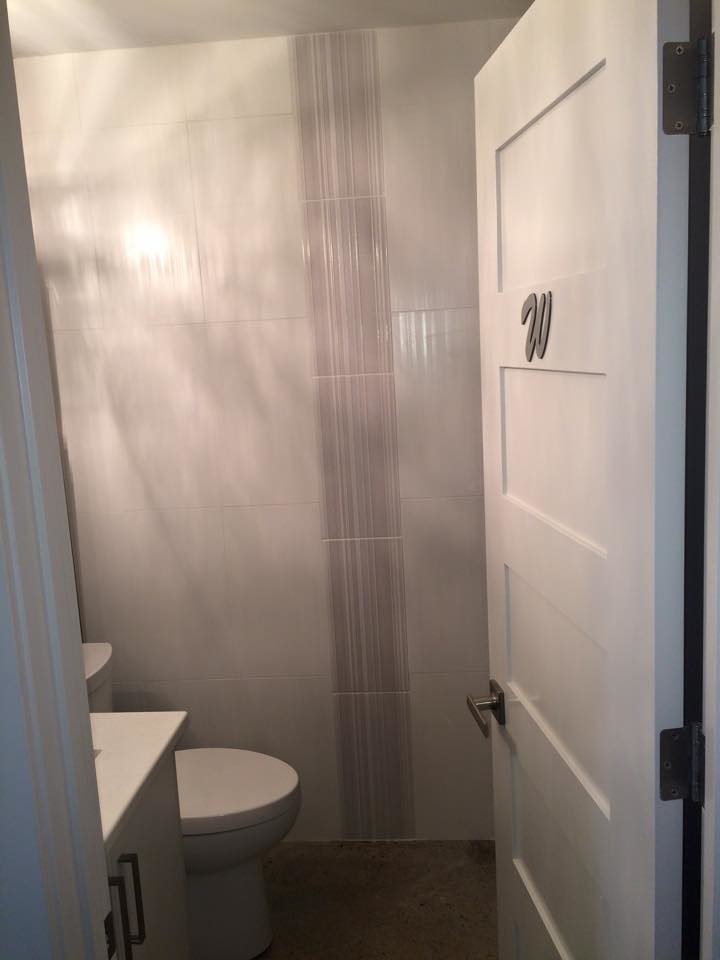 Kleines Modernes Duschbad mit Unterbauwaschbecken, flächenbündigen Schrankfronten, weißen Schränken, Quarzwerkstein-Waschtisch, Wandtoilette mit Spülkasten, weißen Fliesen, grauer Wandfarbe und Betonboden in Calgary