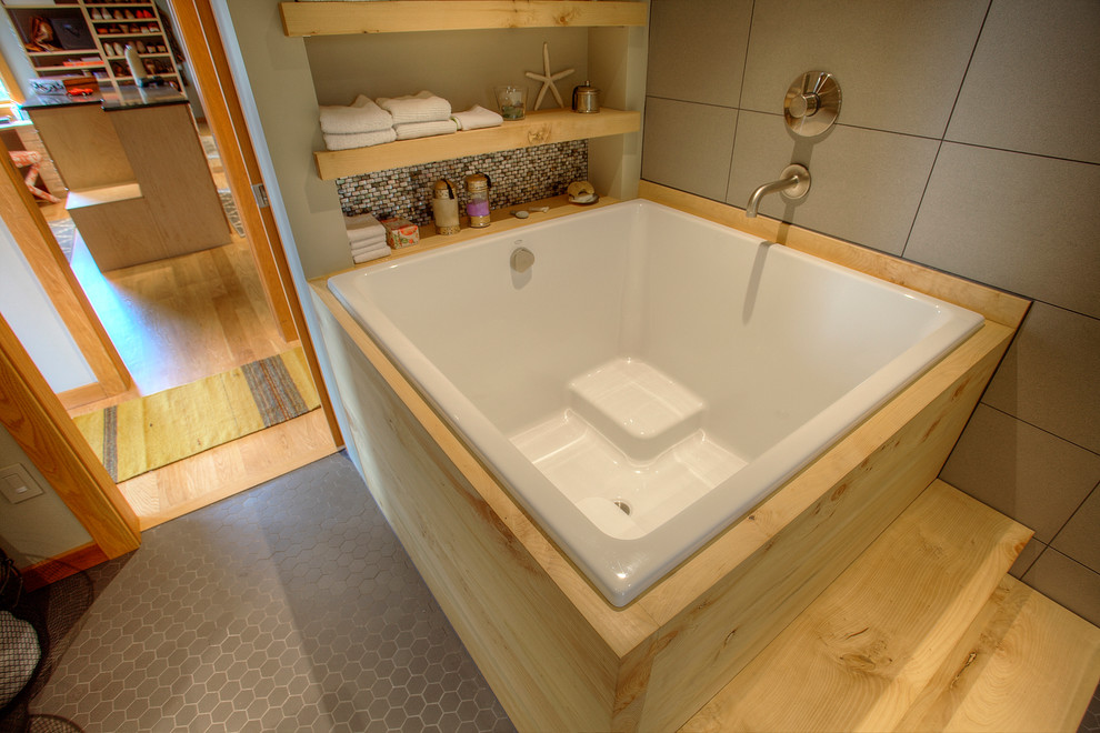 Aménagement d'une grande salle de bain principale asiatique avec un bain japonais, un carrelage gris, des carreaux de porcelaine, un mur gris et un sol en carrelage de porcelaine.