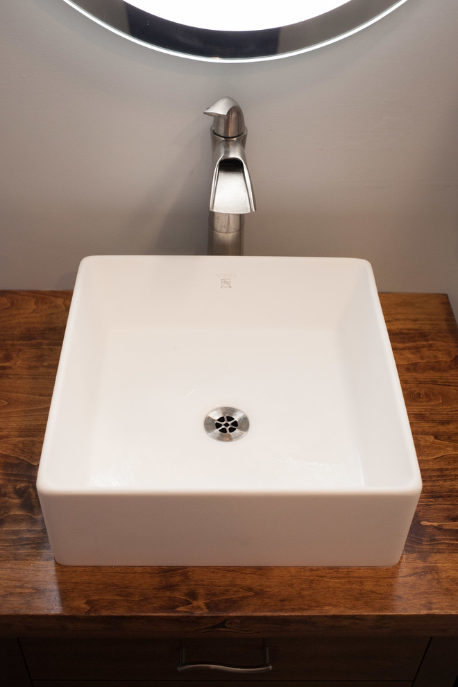 Kleines Uriges Badezimmer mit flächenbündigen Schrankfronten, dunklen Holzschränken, beigen Fliesen, grauer Wandfarbe, Linoleum, Aufsatzwaschbecken und Waschtisch aus Holz in Portland Maine