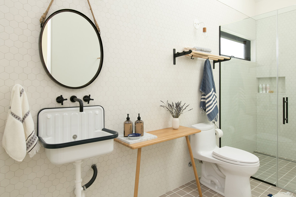Пример оригинального дизайна: ванная комната в стиле кантри с душем без бортиков, унитазом-моноблоком, белой плиткой, плиткой мозаикой, белыми стенами, подвесной раковиной, столешницей из дерева, серым полом, душем с распашными дверями и коричневой столешницей