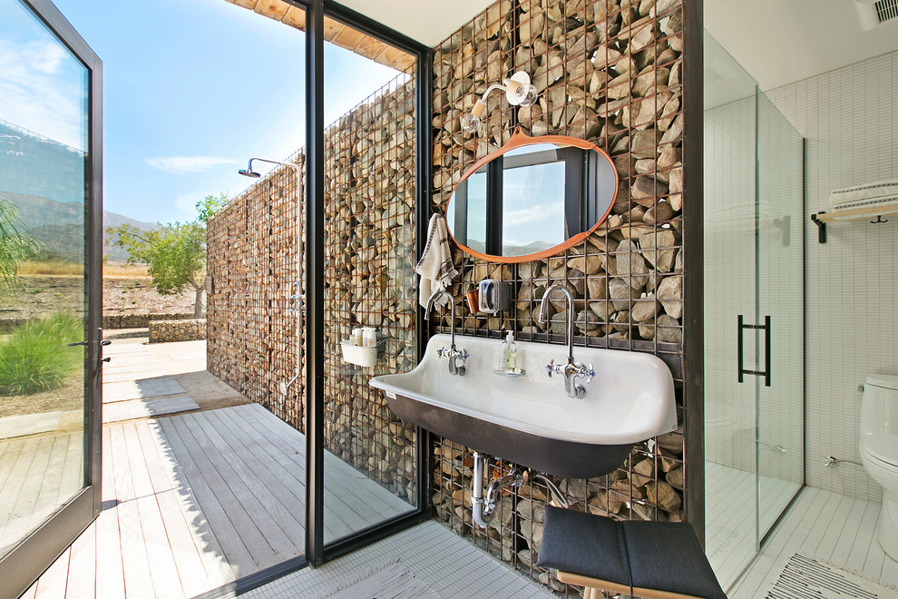 Landhaus Badezimmer mit Duschnische, weißen Fliesen, Mosaikfliesen, Mosaik-Bodenfliesen, Trogwaschbecken, weißem Boden, Falttür-Duschabtrennung und Steinwänden in Los Angeles
