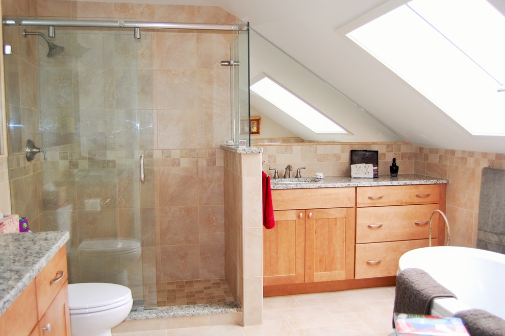 Aménagement d'une salle de bain principale craftsman en bois clair de taille moyenne avec un lavabo encastré, un placard à porte shaker, un plan de toilette en granite, une baignoire sur pieds, une douche ouverte, un carrelage beige et un mur beige.