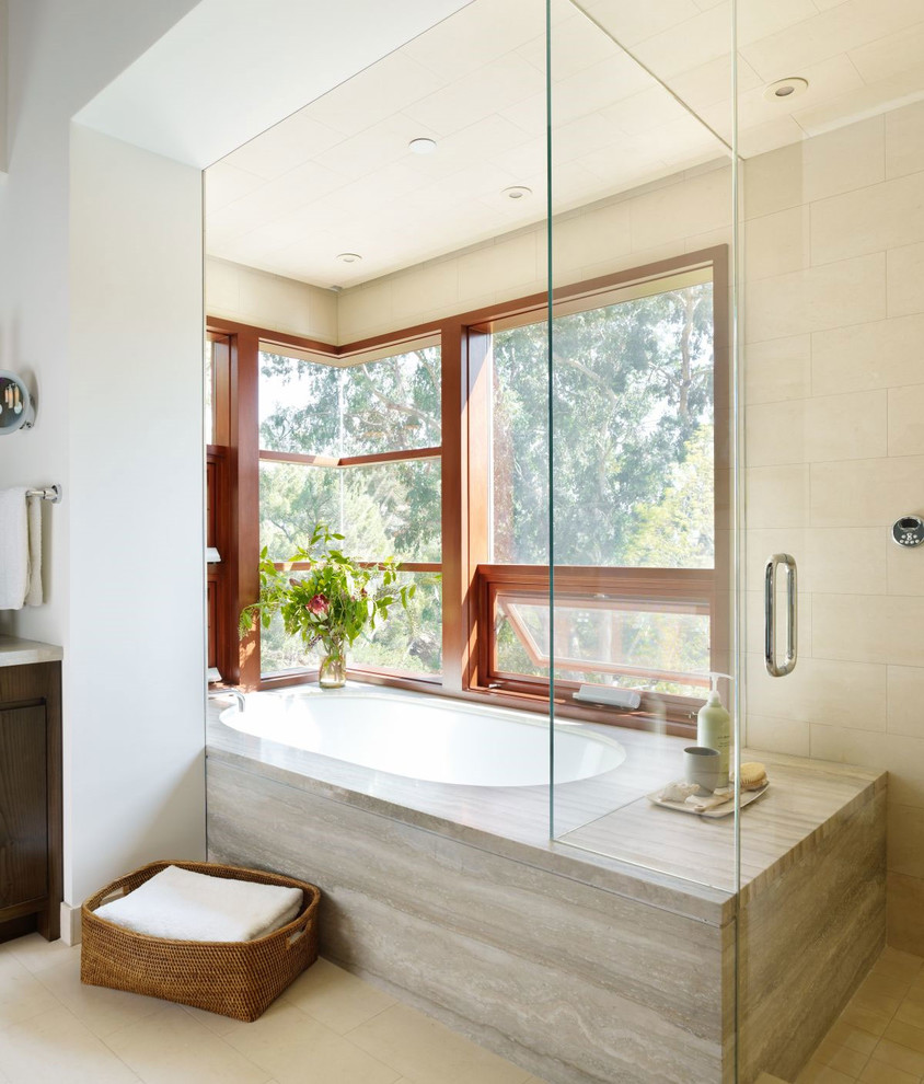 Idée de décoration pour une salle de bain design avec une baignoire encastrée, une douche d'angle et un carrelage beige.