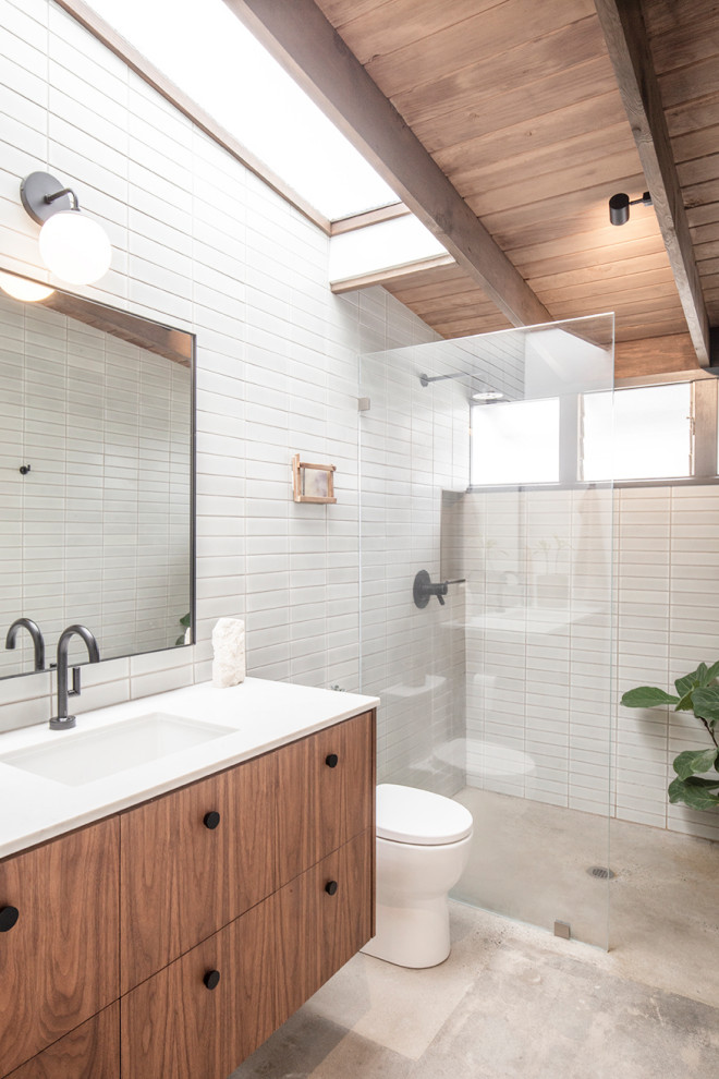 Inspiration for a midcentury bathroom in Orange County with flat-panel cabinets, medium wood cabinets, a built-in shower, white tiles, concrete flooring, a submerged sink, grey floors, an open shower, white worktops, a single sink, a floating vanity unit and a vaulted ceiling.