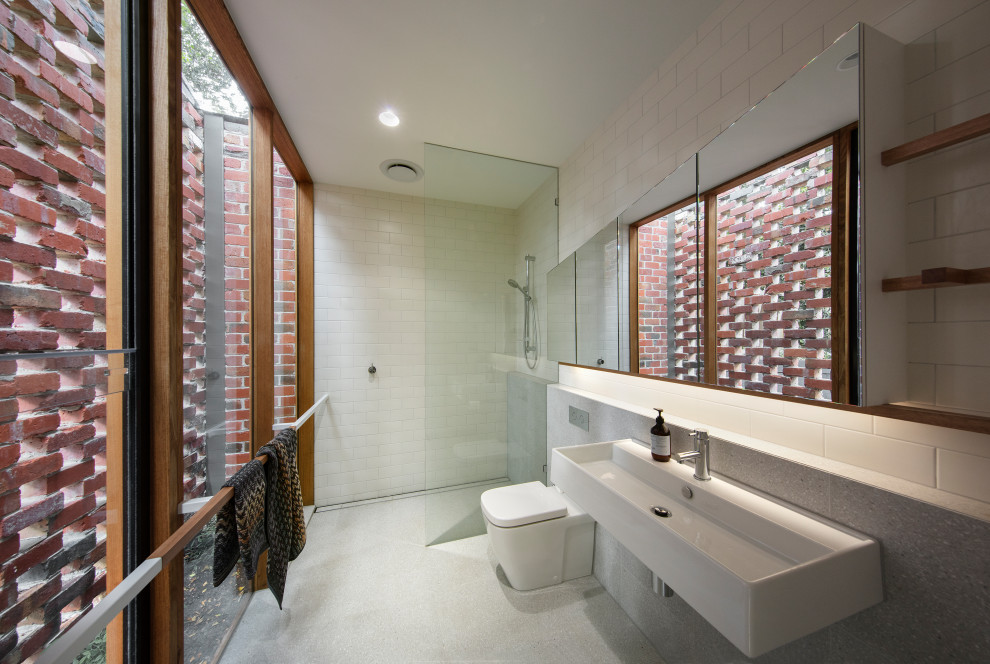 Inspiration för små moderna en-suite badrum, med en toalettstol med hel cisternkåpa, vit kakel, keramikplattor, klinkergolv i keramik, ett väggmonterat handfat, grått golv, med dusch som är öppen och en kantlös dusch