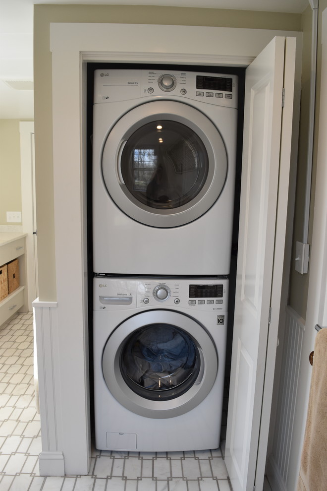 Imagen de lavadero tradicional renovado de tamaño medio con armarios con paneles lisos, puertas de armario grises, suelo de mármol, suelo blanco y paredes beige
