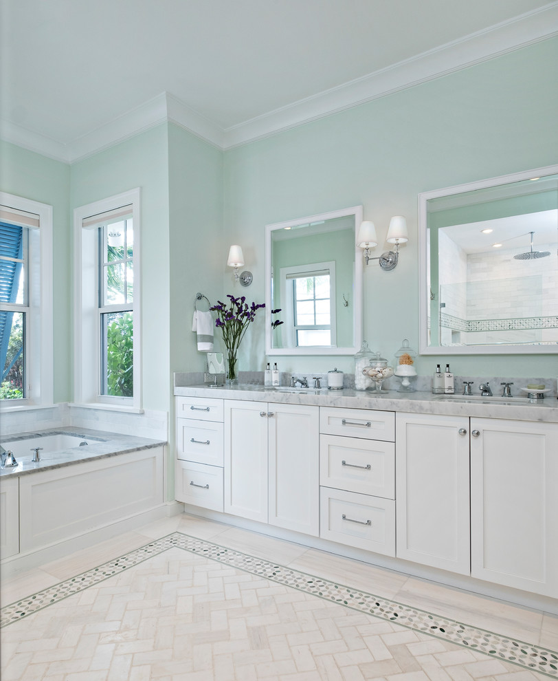 На фото: большая главная ванная комната в стиле неоклассика (современная классика) с фасадами в стиле шейкер, белыми фасадами, полновстраиваемой ванной, зелеными стенами, мраморным полом, мраморной столешницей и желтым полом