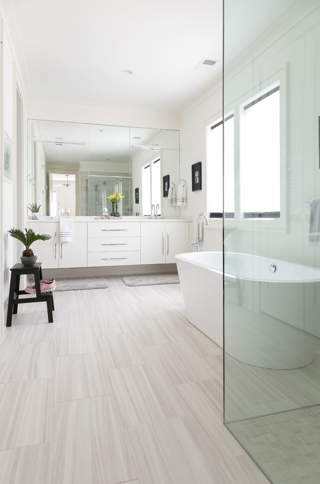 Idéer för att renovera ett funkis vit vitt en-suite badrum, med släta luckor, vita skåp, ett fristående badkar, en hörndusch, vit kakel, vita väggar, ett nedsänkt handfat, marmorbänkskiva och dusch med gångjärnsdörr
