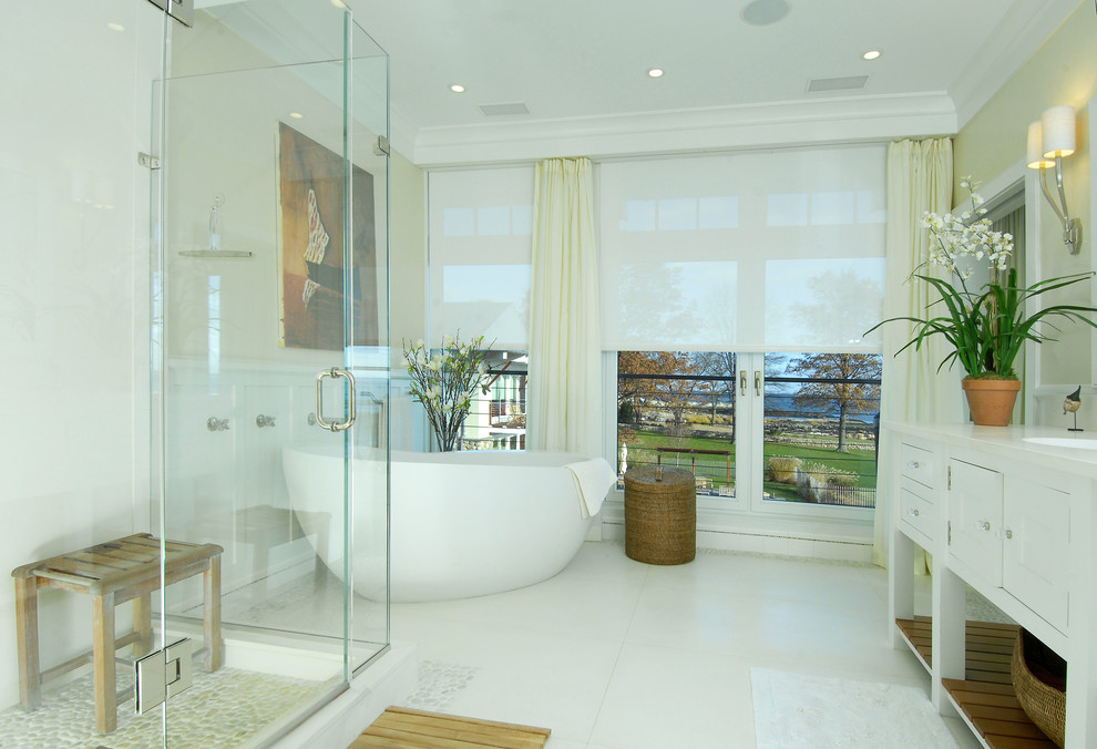 ニューヨークにあるエクレクティックスタイルのおしゃれな浴室 (アンダーカウンター洗面器、白いキャビネット、置き型浴槽、コーナー設置型シャワー、白いタイル、シェーカースタイル扉のキャビネット) の写真