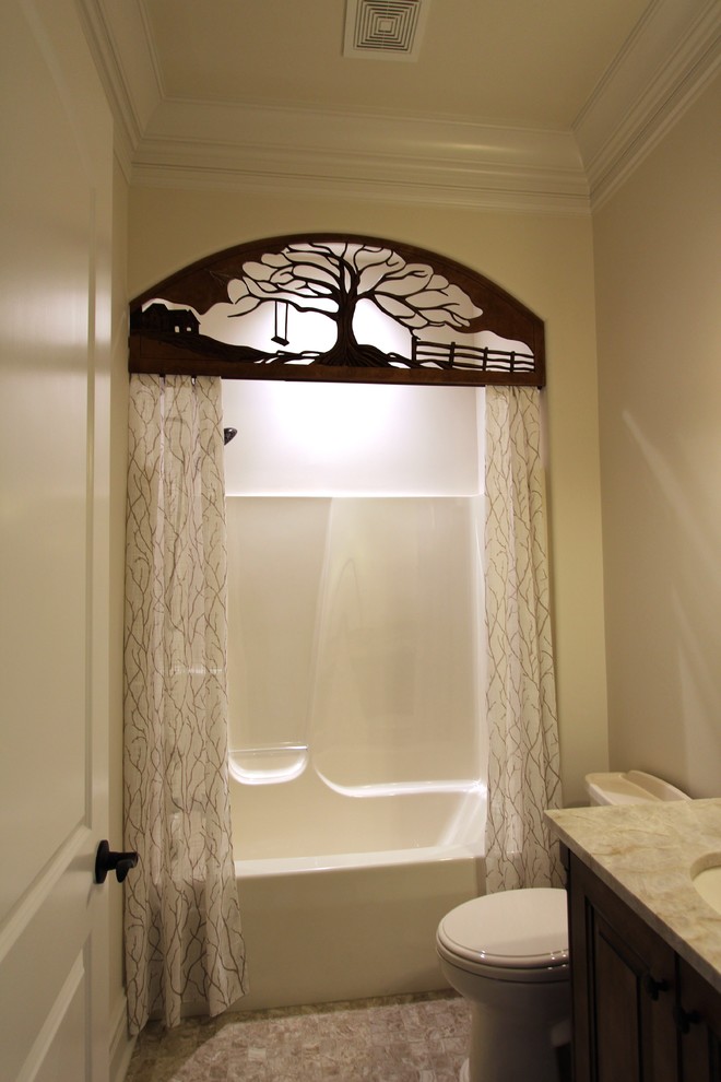 ナッシュビルにある高級な中くらいなトラディショナルスタイルのおしゃれな浴室 (レイズドパネル扉のキャビネット、濃色木目調キャビネット、御影石の洗面台、シャワー付き浴槽	、ベージュのタイル、セラミックタイル、ベージュの壁、セラミックタイルの床、一体型トイレ	、シャワーカーテン) の写真