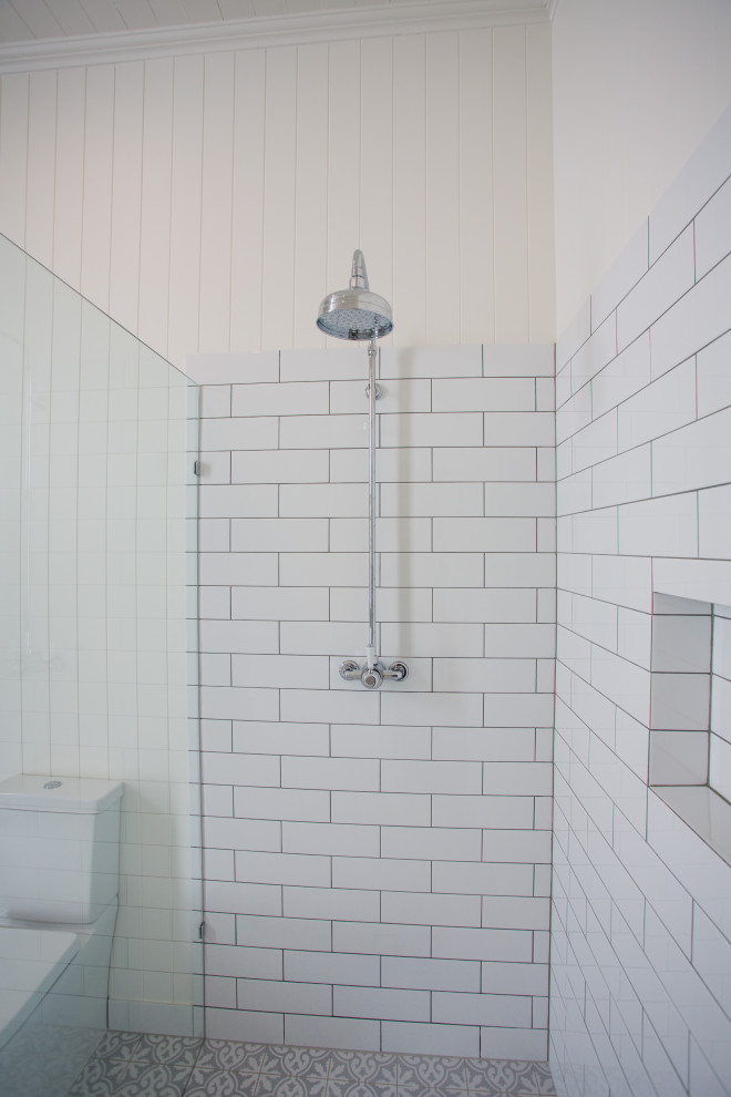 Exempel på ett stort modernt vit vitt en-suite badrum, med möbel-liknande, grå skåp, ett fristående badkar, en hörndusch, en toalettstol med hel cisternkåpa, vit kakel, vita väggar, klinkergolv i keramik, ett nedsänkt handfat, marmorbänkskiva och blått golv