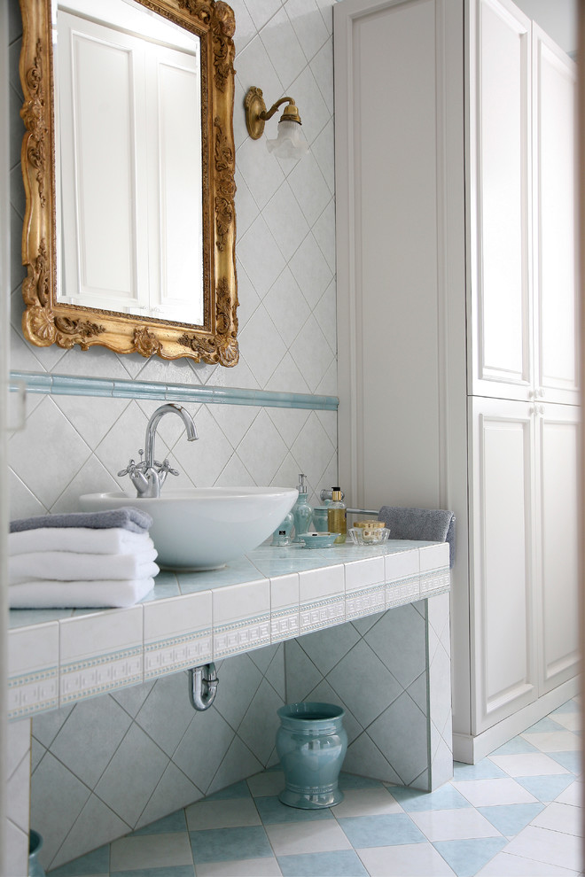 Exemple d'une salle de bain principale victorienne de taille moyenne avec une vasque, des portes de placard blanches, des carreaux de céramique, un mur blanc, un sol en carrelage de céramique et du carrelage bicolore.