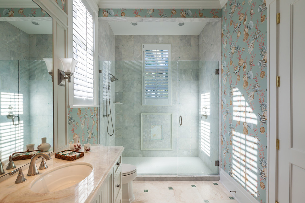 Diseño de cuarto de baño tradicional con lavabo bajoencimera, puertas de armario blancas, ducha empotrada, baldosas y/o azulejos grises y ventanas